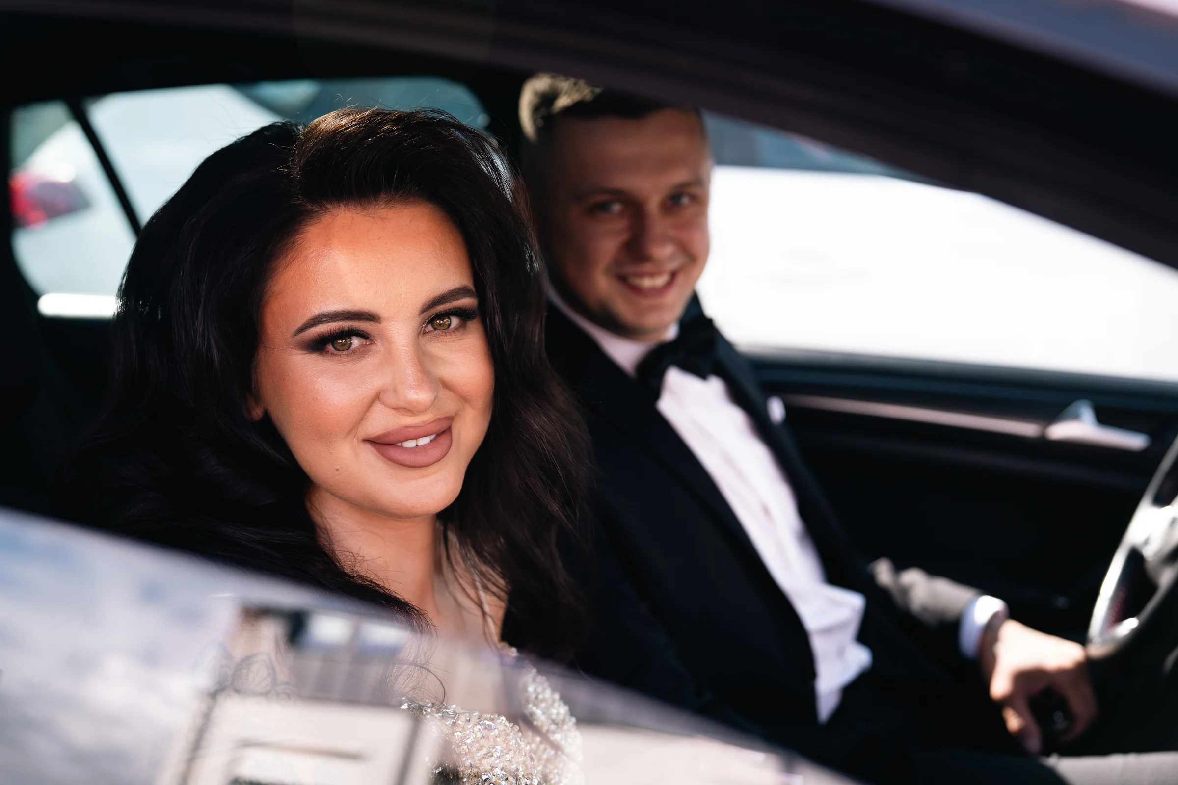 Panna młoda i partner spoglądają z wnętrza samochodu
