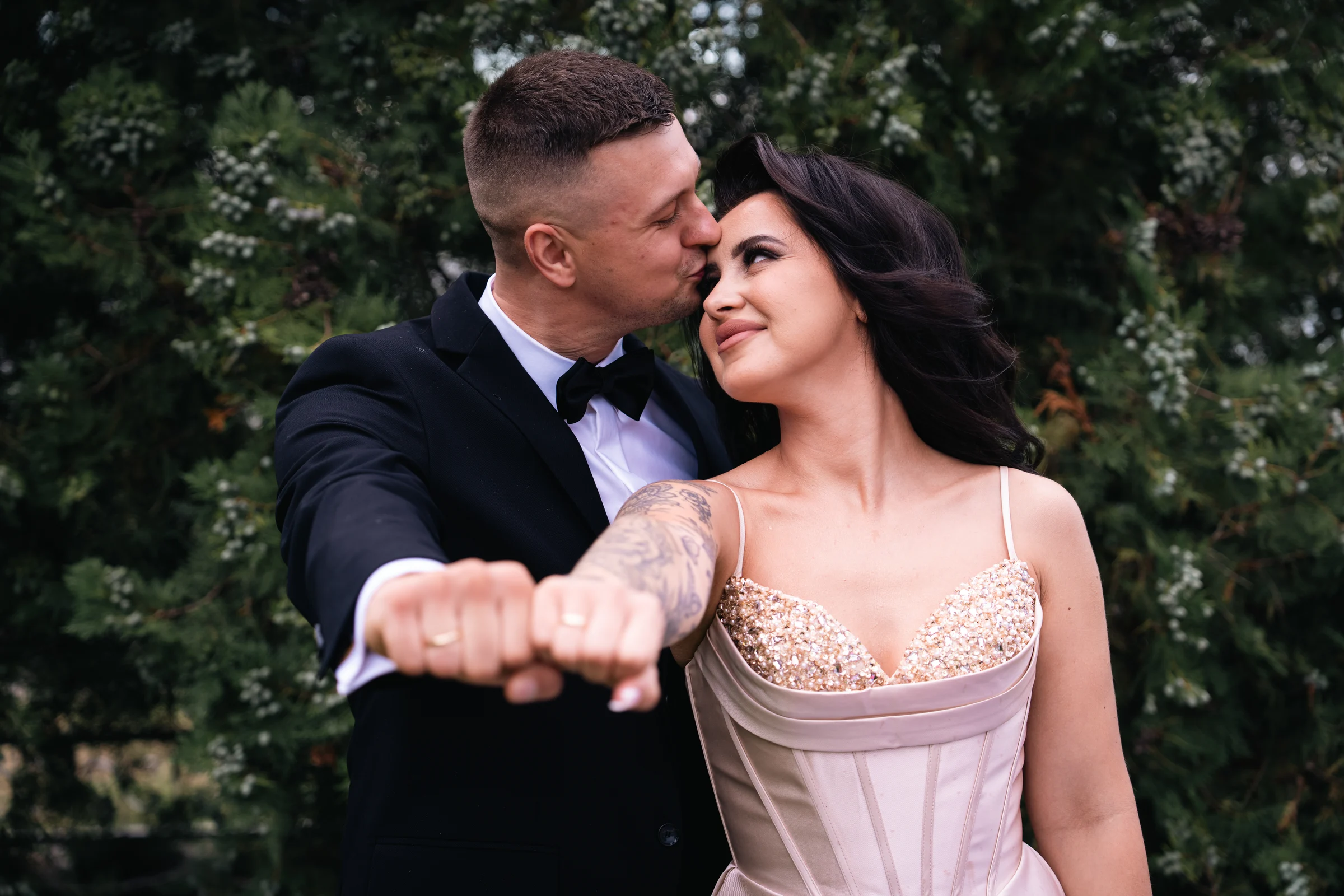 Para pokazuje obrączki, partner całuje pannę młodą