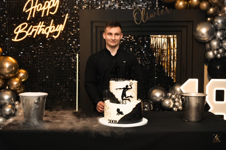 Jubilat i tort na tle dekoracji — Urodziny Oliwiera