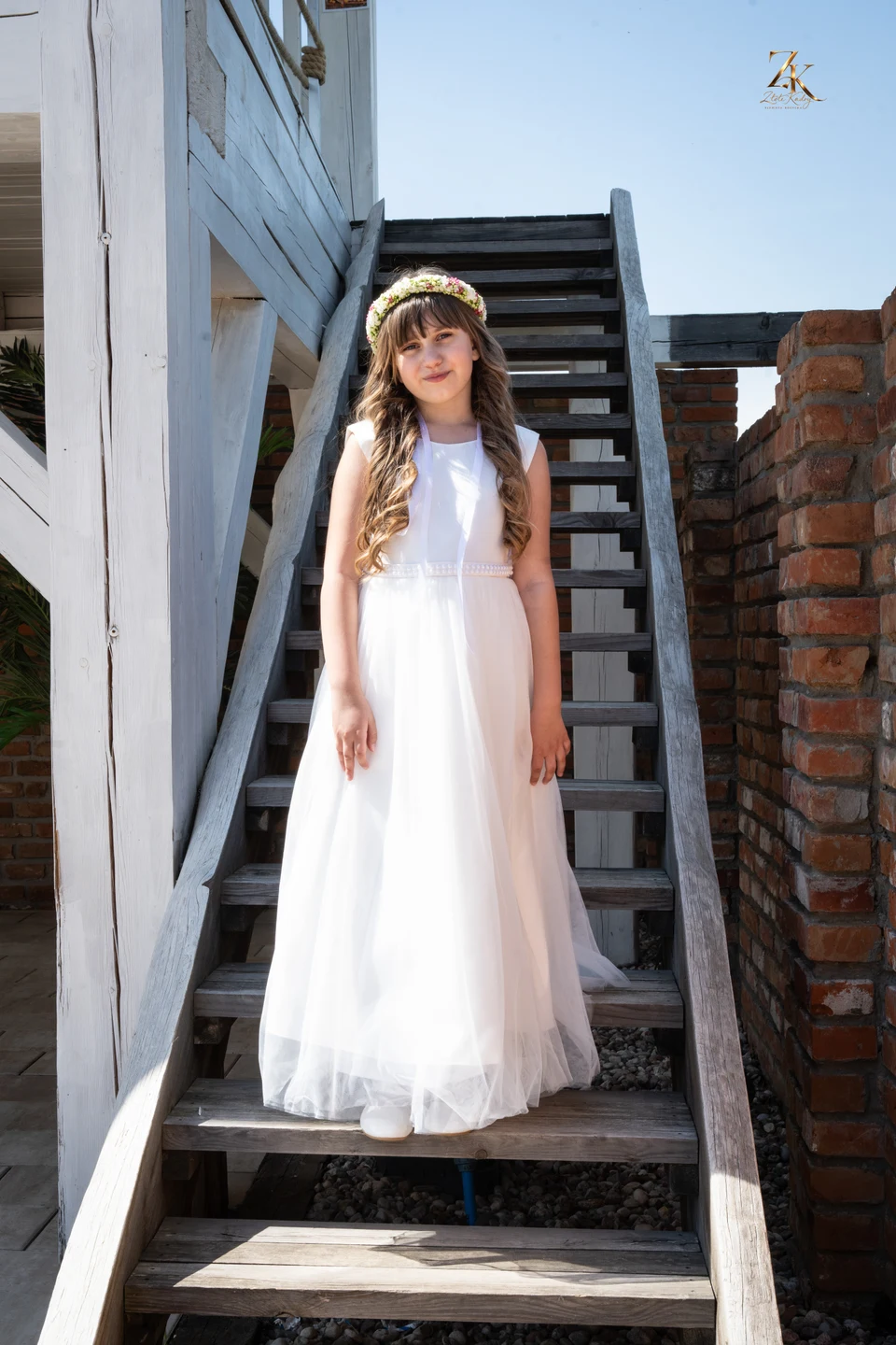 Portret Antosi w białej sukni przy drzwiach — Komunia Antosi
