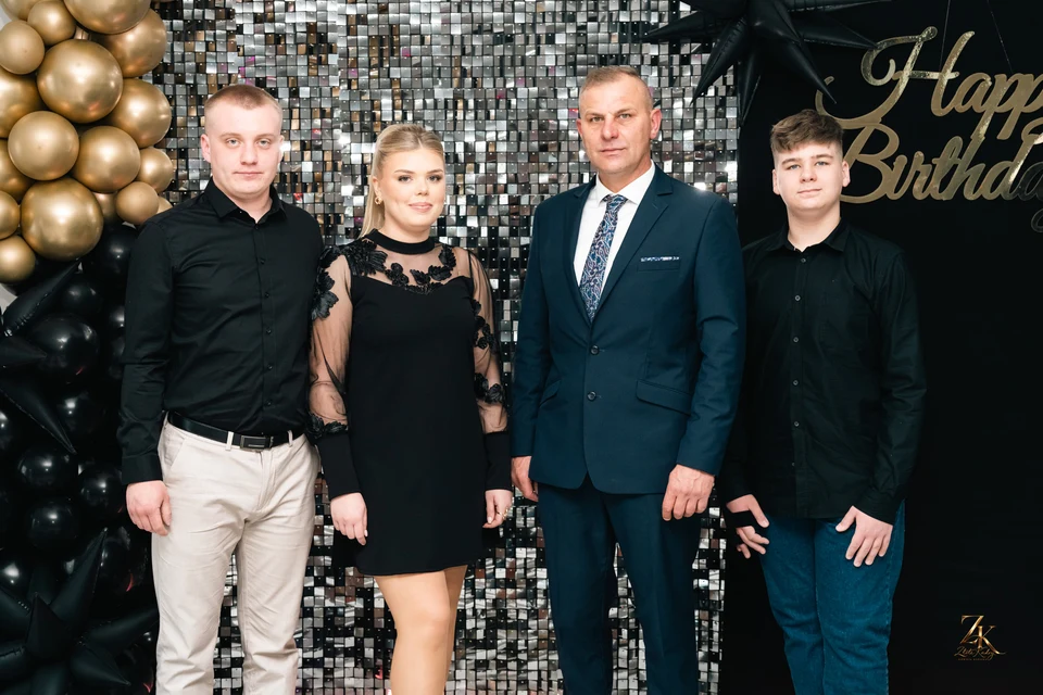 Pamiątkowy portret gości na tle dekoracji jubileuszowej